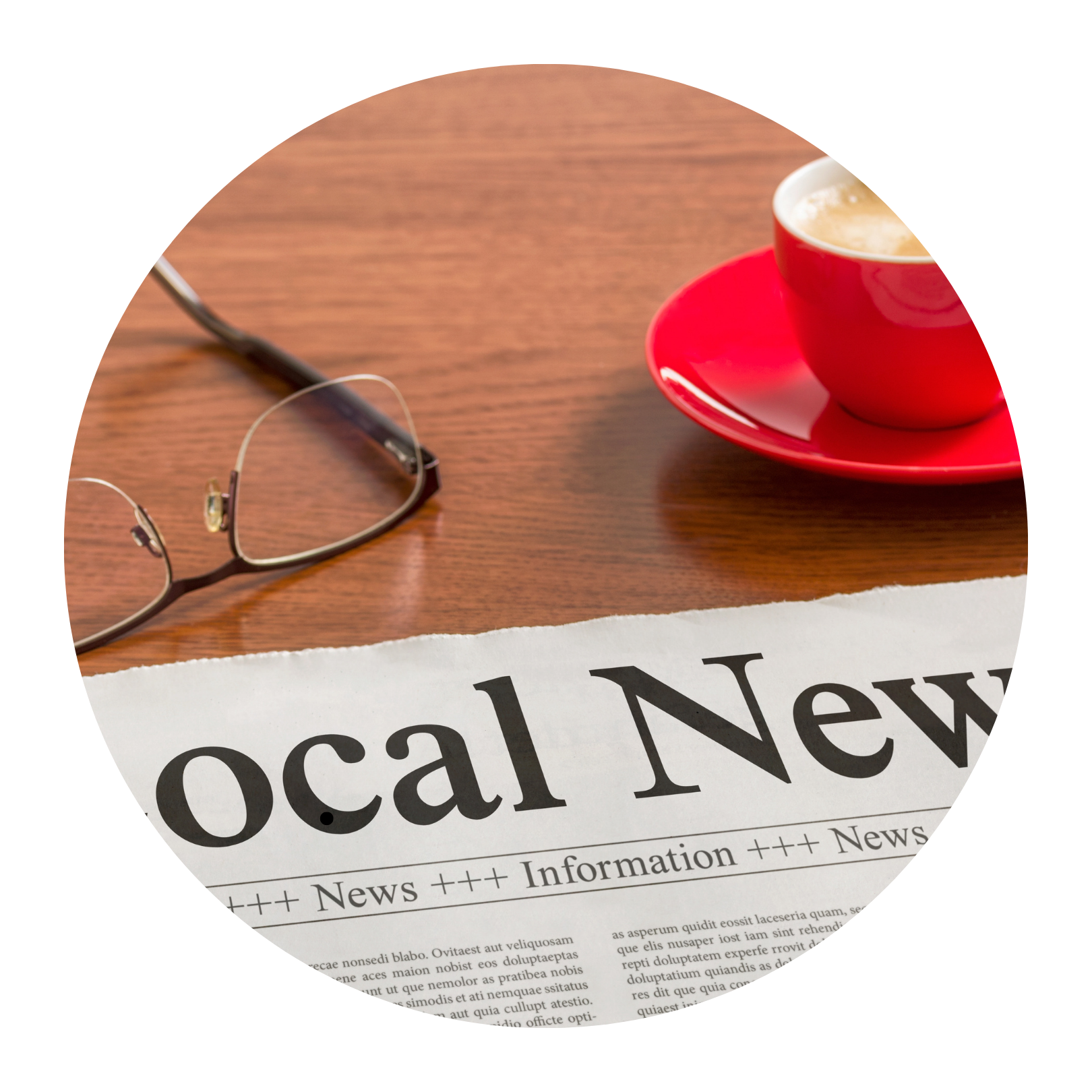 Glasses, a cup of coffee and a local newspaper on a desk.